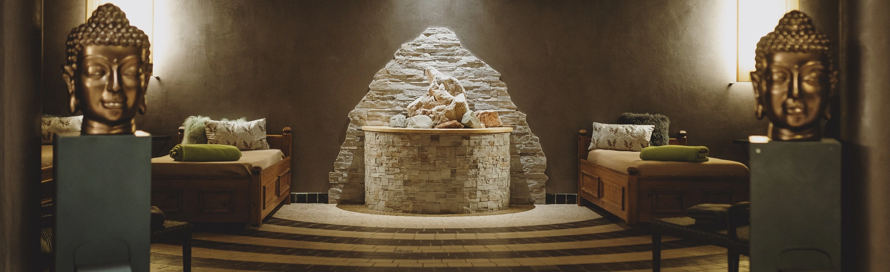Entspannungsbereich mit Buddha-Statuen und Kamin
