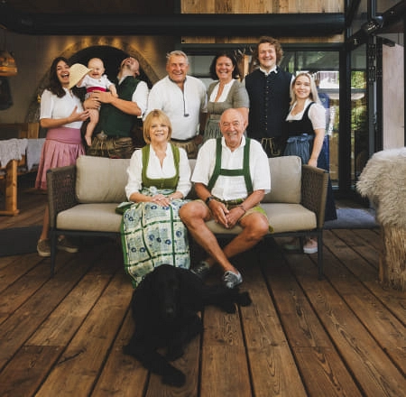 Familienfoto im Wohnzimmer mit traditionellen Trachten.
