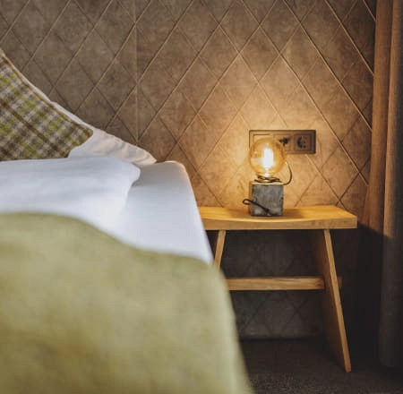 Nachttisch mit Lampe neben einem Bett