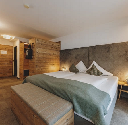 Helles Zimmer mit Holzdetails und modernem Bett.