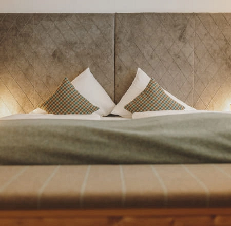 Bett mit Kissen und indirekter Beleuchtung im Zimmer