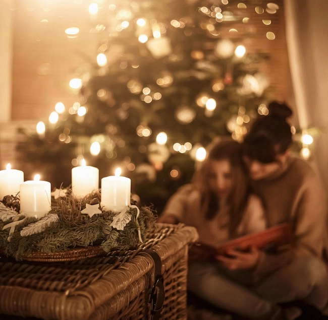 Weihnachtsbaum im Hintergrund, Kerzen auf einem Korb.