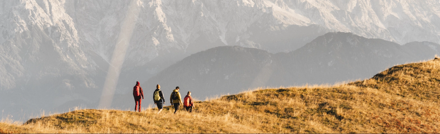 Wanderer auf einer herbstlichen Wiese in Saalbach Hinterglemm